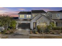 Charming two-story home featuring a modern garage door and well-manicured landscaping at 10150 E Thistle Ave, Mesa, AZ 85212