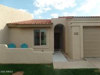 Charming single-story home with a well-maintained lawn, two blue chairs, and a tile roof at 1021 S Greenfield Rd # 1106, Mesa, AZ 85206