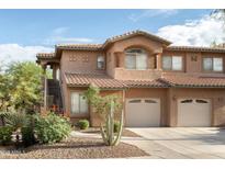 Charming townhome featuring a terracotta roof, attached garage and desert landscaping at 11500 E Cochise Dr # 1063, Scottsdale, AZ 85259