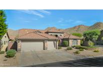 Charming single-Gathering home with a three-car garage and desert landscaping, set against a backdrop of scenic mountains at 13896 E Kalil Dr, Scottsdale, AZ 85259