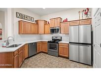 Well-lit kitchen featuring stainless steel appliances, wooden cabinets, and bright countertops at 14575 W Mountain View Blvd # 11310, Surprise, AZ 85374