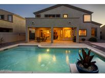 Relaxing backyard pool with covered patio and outdoor seating, perfect for entertaining at twilight at 18346 W Sweet Acacia Dr, Goodyear, AZ 85338