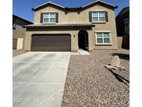 Two-story home featuring a brown garage door, neutral stucco exterior and low maintenance gravel landscaping at 36992 W Capri Ave, Maricopa, AZ 85138