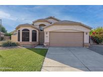 Charming single-Gathering home featuring a two-car garage, low maintenance landscaping, and a desert-style front yard at 6439 W Adobe Dr, Glendale, AZ 85308