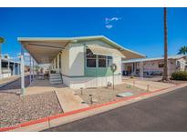 Charming single story home featuring covered parking, a well-manicured yard, and mature palm trees at 9828 E Pueblo Ave # 113, Mesa, AZ 85208