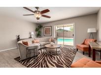Bright living room with a zebra rug, stylish furnishings, and a sliding glass door to the pool at 2223 W 8Th Ave, Mesa, AZ 85202