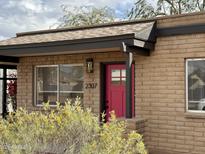 Charming home featuring a vibrant pink front door and well-maintained desert landscaping at 2307 W Sierra St, Phoenix, AZ 85029