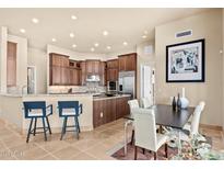 Open concept kitchen with stainless steel appliances, counter seating and adjacent dining area at 37015 N 27Th Pl, Cave Creek, AZ 85331