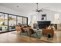 Bright living room boasts a modern fireplace, sleek furniture, and a seamless indoor-outdoor flow to the pool area at 4318 E Cheery Lynn Rd, Phoenix, AZ 85018