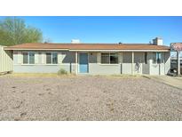 Charming single-story home with a well-maintained exterior and inviting blue front door at 701 N 95Th Cir, Mesa, AZ 85207