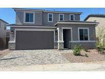 Two-story home featuring a gray stucco exterior, a large garage, and a well-manicured yard at 11619 W Green Dr, Youngtown, AZ 85363