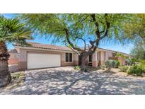 Charming single-story home featuring a two-car garage, desert landscaping, and a lovely mature shade tree at 13587 W Cypress St, Goodyear, AZ 85395