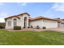 Charming single-story home featuring a well-manicured lawn, tiled roof, and an attached two-car garage at 5426 E Fountain Cir, Mesa, AZ 85205