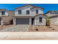Inviting two-story home featuring desert landscaping, a paver driveway, and a two-car garage at 11627 W Green Dr, Youngtown, AZ 85363