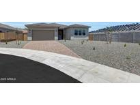 Charming single-story home with a two-car garage, neutral stucco, desert rock landscaping and paver driveway at 13448 W Auburn Dr, Peoria, AZ 85383