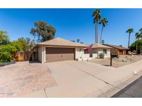 Charming single-story home with a two-car garage, desert landscaping, and a welcoming facade at 1434 W Meseto Ave, Mesa, AZ 85202