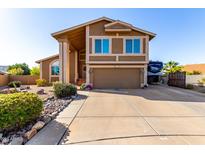 Inviting two-story home featuring desert landscaping and a spacious driveway at 17466 N 64Th Ave, Glendale, AZ 85308