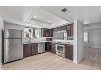 Modern kitchen boasts stainless steel appliances, dark cabinetry, and bright, neutral flooring at 2828 E Waltann Ln # 1, Phoenix, AZ 85032