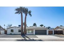 Charming single-story home featuring a two-car garage, desert landscaping, and tall palm trees at 3417 E Lupine Ave, Phoenix, AZ 85028