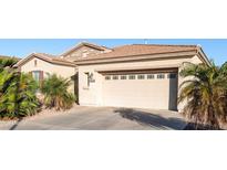 Attached garage with concrete driveway and desert landscaping in the front yard at 4214 E Donato Dr, Gilbert, AZ 85298