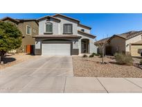 Two-story home boasts a neutral stucco exterior, two-car garage, and easy-care desert landscaping at 706 W Green Tree Dr, San Tan Valley, AZ 85143
