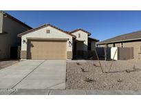 Charming single-story home with a two-car garage and desert landscaping in front at 7272 E Hackamore Ln, San Tan Valley, AZ 85143
