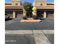 A close exterior shows a two-story townhouse with brown garages and xeriscaping at 8302 N 21St Dr # L204, Phoenix, AZ 85021