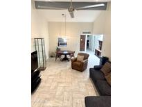 Bright living area features tile floors, high ceilings, stylish furniture, and a modern ceiling fan at 8302 N 21St Dr # L204, Phoenix, AZ 85021