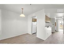 Bright dining room with light wood floors and a view into the kitchen with white refrigerator at 12123 W Bell Rd # 241, Surprise, AZ 85378