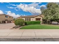Well-maintained home with artificial turf lawn, mature landscaping and trimmed hedges at 4318 N 180Th Dr, Goodyear, AZ 85395