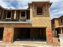 Unfinished new home construction, framed and boarded with open garage and a sunny sky backdrop at 5832 E Covey Ln, Phoenix, AZ 85054