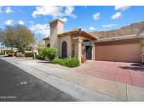 Inviting home featuring red-tiled driveway, desert landscaping, and a neutral color palette at 7955 E Chaparral Rd # 115, Scottsdale, AZ 85250