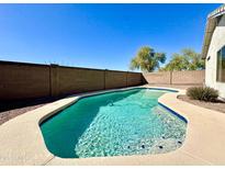 Inviting in-ground pool surrounded by concrete and privacy walls, perfect for relaxing outdoors at 13253 W Lisbon Ln, Surprise, AZ 85379