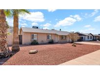 Charming single-story home featuring a well-kept landscape with a palm tree in a desert environment, perfect for serene living at 1633 W Andorra Dr, Phoenix, AZ 85029