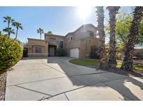Spacious home featuring a large driveway, well-manicured lawn and mature palm trees at 1785 S Morrison Ln, Gilbert, AZ 85295