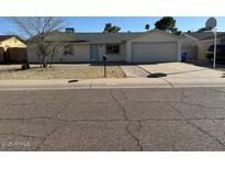 Charming single-story home featuring a well-maintained front yard and a two-car garage at 3515 E Winchcomb Dr, Phoenix, AZ 85032