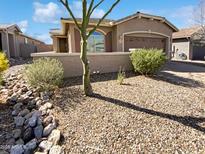 Charming single-story home featuring desert landscaping, an attached garage, and a welcoming front entry at 4127 W Acorn Valley Trl, New River, AZ 85087