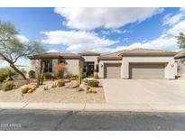 Charming single-story home with a three-car garage and desert landscaping in front at 6340 E Marioca Cir, Scottsdale, AZ 85266