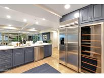 Modern kitchen features stainless steel appliances, blue cabinets, tile floors, and a large island with seating at 7151 E Rancho Vista Dr # 2006, Scottsdale, AZ 85251