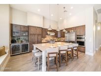The spacious kitchen features an island with seating, pendant lighting, and high-end stainless steel appliances at 7739 E Evening Glow Dr, Scottsdale, AZ 85266