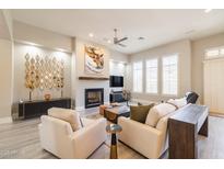 Bright living room boasts a fireplace, ceiling fan, and neutral colors, perfect for relaxation and entertaining guests at 7739 E Evening Glow Dr, Scottsdale, AZ 85266