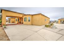 Spacious stucco home featuring a large yard and attached garage with porte-cochere at 8210 S 132Nd Ave, Goodyear, AZ 85338