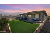 Home backyard featuring drought tolerant rock landscaping, modern lighting and artificial turf at 17286 W Running Deer Trl, Surprise, AZ 85387
