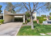 Charming single-story home with a covered carport and lush green lawn, perfect for suburban living at 2910 E Avenida Olivos --, Phoenix, AZ 85016