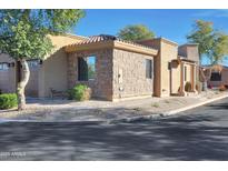 Beautiful home exterior with a stone facade, desert landscaping, and a tile roof at 4241 N Pebblecreek Pkwy # 54, Goodyear, AZ 85395
