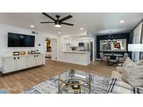 Bright living room with modern furniture, ceiling fan, and seamless flow to kitchen and dining at 5209 N 24Th St # 104, Phoenix, AZ 85016