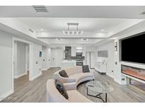 Bright living room featuring modern lighting, fireplace, television and an open floorplan flowing into the kitchen at 7151 E Rancho Vista Dr # 1003, Scottsdale, AZ 85251