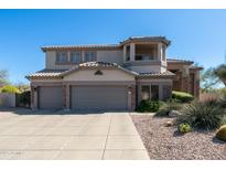 Stunning two-story home featuring a three-car garage and desert landscaping at 7424 E Sandia Cir, Mesa, AZ 85207