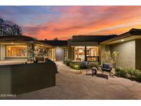 Inviting home exterior featuring warm sunset colors, front patio seating, and unique architectural details at 8724 N 68Th St, Paradise Valley, AZ 85253