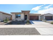 Charming single-story home featuring stone accents, a two-car garage, and low maintenance desert landscaping at 17893 W Indigo Brush Rd, Goodyear, AZ 85338